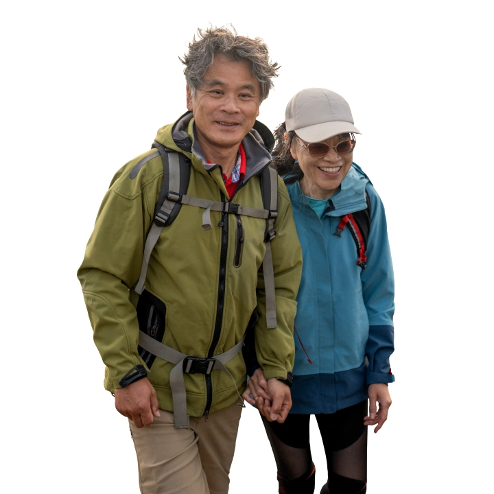  middle-aged couple in rain jackets walking on the beach